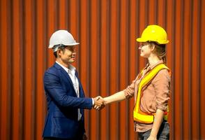 Business man and industrial worker woman shaking hands photo