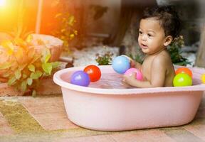 asiático bebé baños en tinas foto