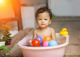 asiático bebé baños en tinas foto