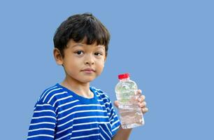 niño sediento agua y sostener transparente el plastico agua botella agua foto