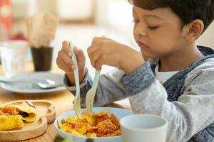 niños comer tortilla envuelto en tocino salsa frito arroz. foto