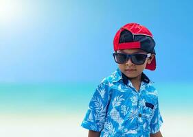 Asian boys wear sunglasses and summer clothes on a bright summer sea background. photo