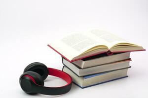 The headphones and lined up books on white background.Knowledge, learning and education concept. photo