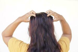 Woman use hands to scratch her itcy hair on head, isolated on white background. Concept, Hair health problems. Dandruff, fungus on scalp, allergic to shampoo or louse. photo