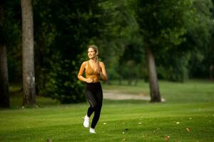 Pretty young woman running in the park photo