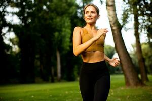 Pretty young woman running in the park photo