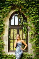 Pretty young woman using mobile phone by the old house with ivy photo