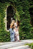 Pretty young women using mobile phone by the old house with ivy photo