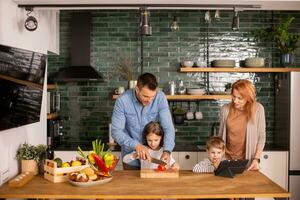 Young family preparing vegetables in the kitchen photo