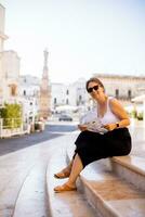 Female tourist with city map by the Saint Oronzo statue in Ostuni, Italy photo