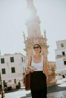 Female tourist with city map by the Saint Oronzo statue in Ostuni, Italy photo