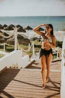 Smiling Young Woman in Bikini Enjoying Vacation on the Beach photo