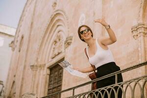 Female tourist with city map by the church San Francesco dAssisi in Ostuni, Italy photo