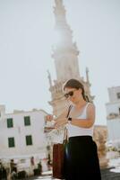 Female tourist with city map by the Saint Oronzo statue in Ostuni, Italy photo