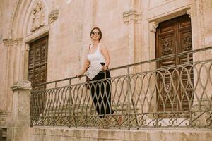 Female tourist with city map by the church San Francesco dAssisi in Ostuni, Italy photo