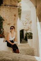 Female tourist with paper city map on narrow streets of Ostuni, Italy photo