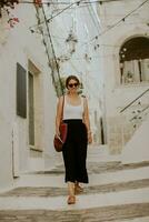 Female tourist with paper city map on narrow streets of Ostuni, Italy photo