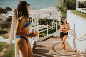 Smiling young women in bikini enjoying vacation on the beach photo