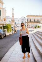 Female tourist with city map by the Saint Oronzo statue in Ostuni, Italy photo