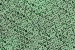 a green metal grate with holes in it photo