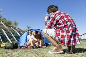 group of friends on vacation takes photos at the campsite