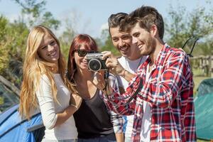 group of young adult watching photos on digital camera