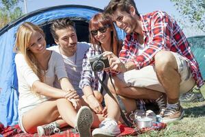 group of young adult watching photos on digital camera