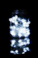 strip of Christmas lights closed inside a glass jar photo