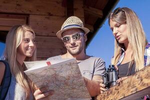 grupo de joven caminantes buscar en el mapa el Derecha camino foto