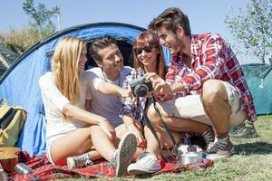 group of young adult watching photos on digital camera