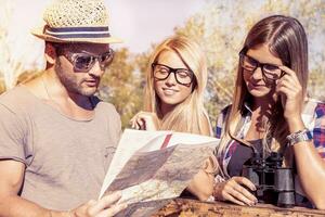 group of young hikers search on the map the right way photo