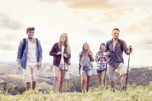 group of young hikers looks to the horizon over the mountain photo