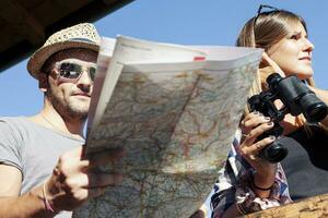 group of young hikers looking at map in the mountain photo