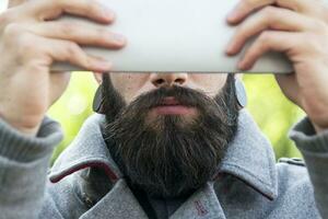 joven hipster empresario participación el ordenador portátil en frente de cara foto