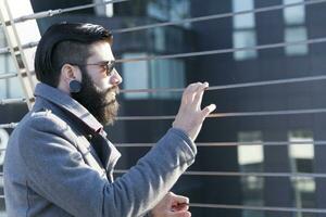 joven hipster empresario Mira a tráfico en un hierro puente foto