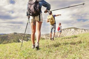 group of young hikers in the mountain in single file photo