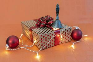 christmas gift and decorative lights on orange background photo