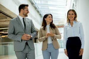 Young startup team have a discussion while walking in the modern office corridor photo