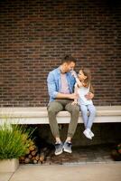 Father and his daughter have a good time in front of house door photo