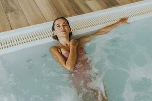 joven mujer relajante en el interior nadando piscina foto