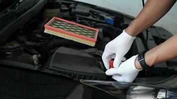 Automotive part concept.Regular car care makes car use. Auto mechanic uses screwdriver to screw in car air filter to replace it video