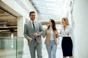 Young startup team have a discussion while walking in the modern office corridor photo