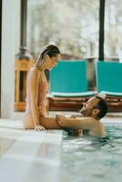 Young couple relaxing in the indoor swimming pool photo