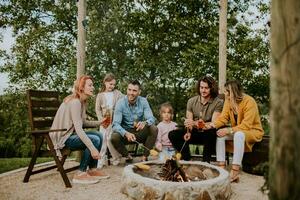 Friends having good time and baking corns in the house backyard photo