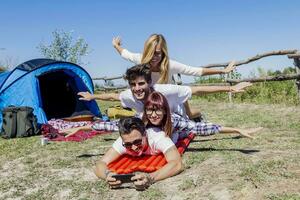 young boys and girls in campsite piled up smiling photo