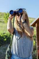 pretty girl with binoculars looking at the horizon photo