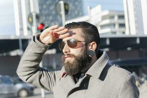 retrato de joven hipster empresario en el corazón de ciudad foto