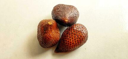 Three snake fruit are located on the floor photo