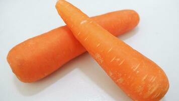 Two very large carrots were placed on the white floor photo