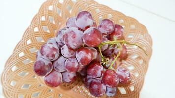 A pile of red grapes is placed in a container photo